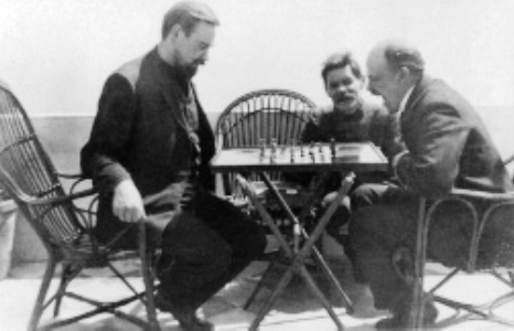 Bogdánov jogando xadrez com Lenin em Capri, Gorki ao fundo, abril de 1908, foto de Iúri Jeliábujski